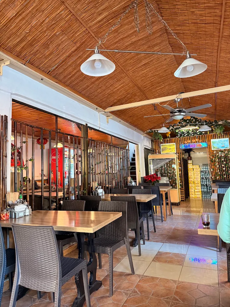 Dining room at Ha Noi Limassol with bamboo ceiling and wooden tables